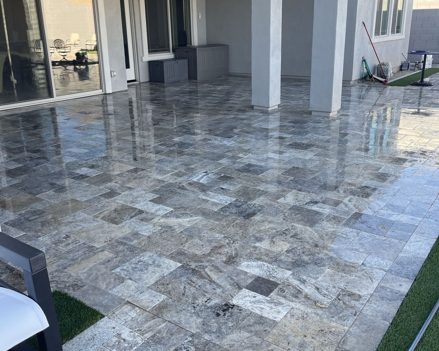 A travertine patio at a Phoenix home, freshly pressure washed and still wet