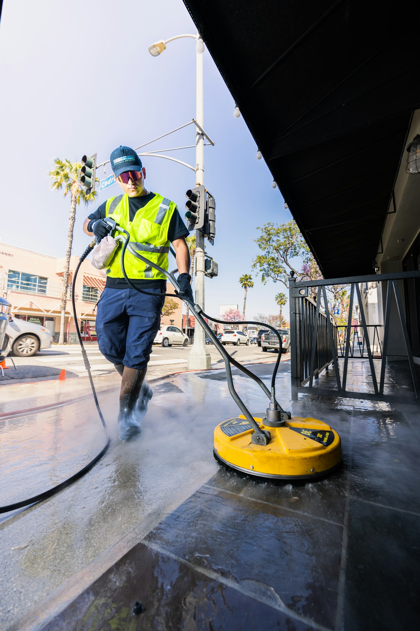 Professional technician pressure washing a surface clean on a sunny day