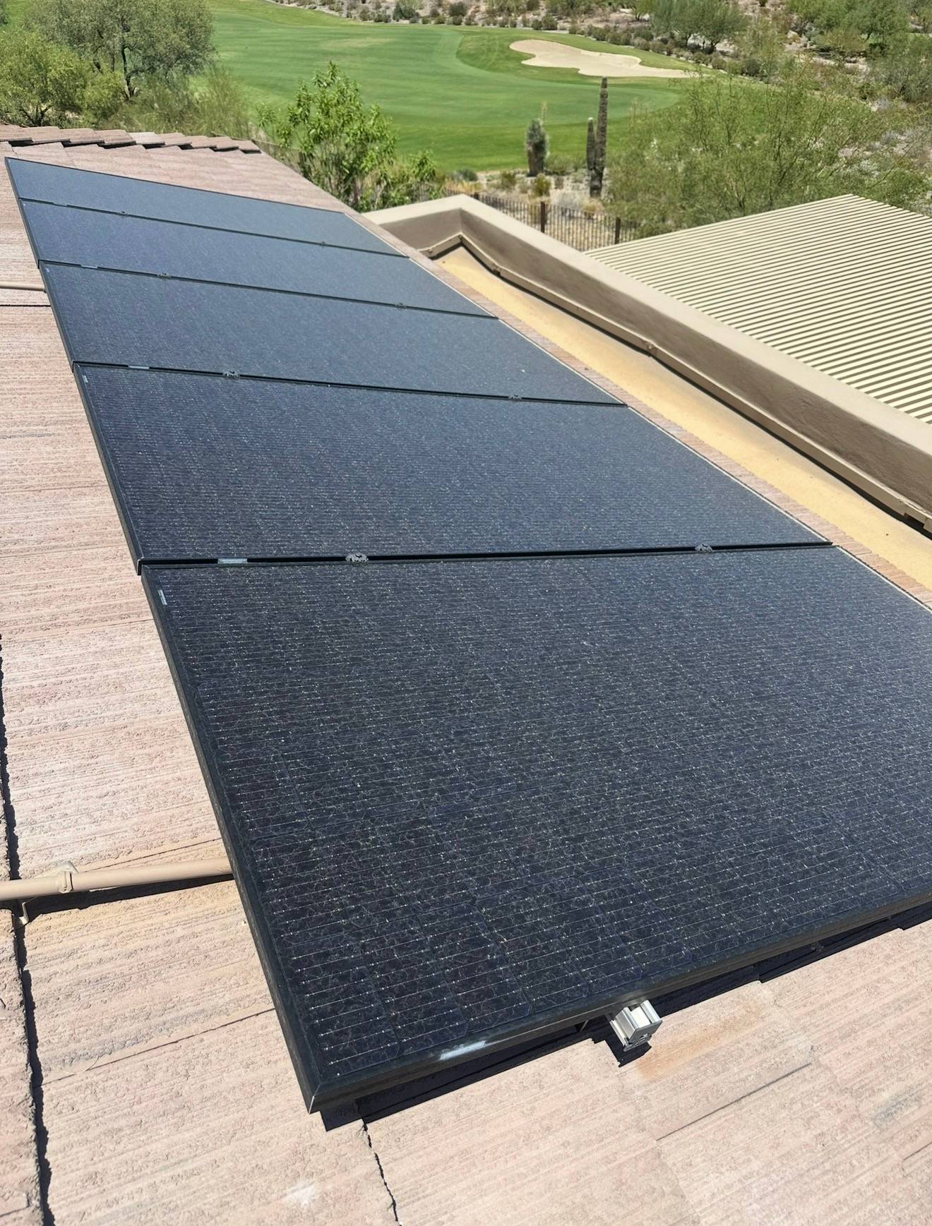 A roof-mounted solar array before cleaning, panels dulled by Valley dust