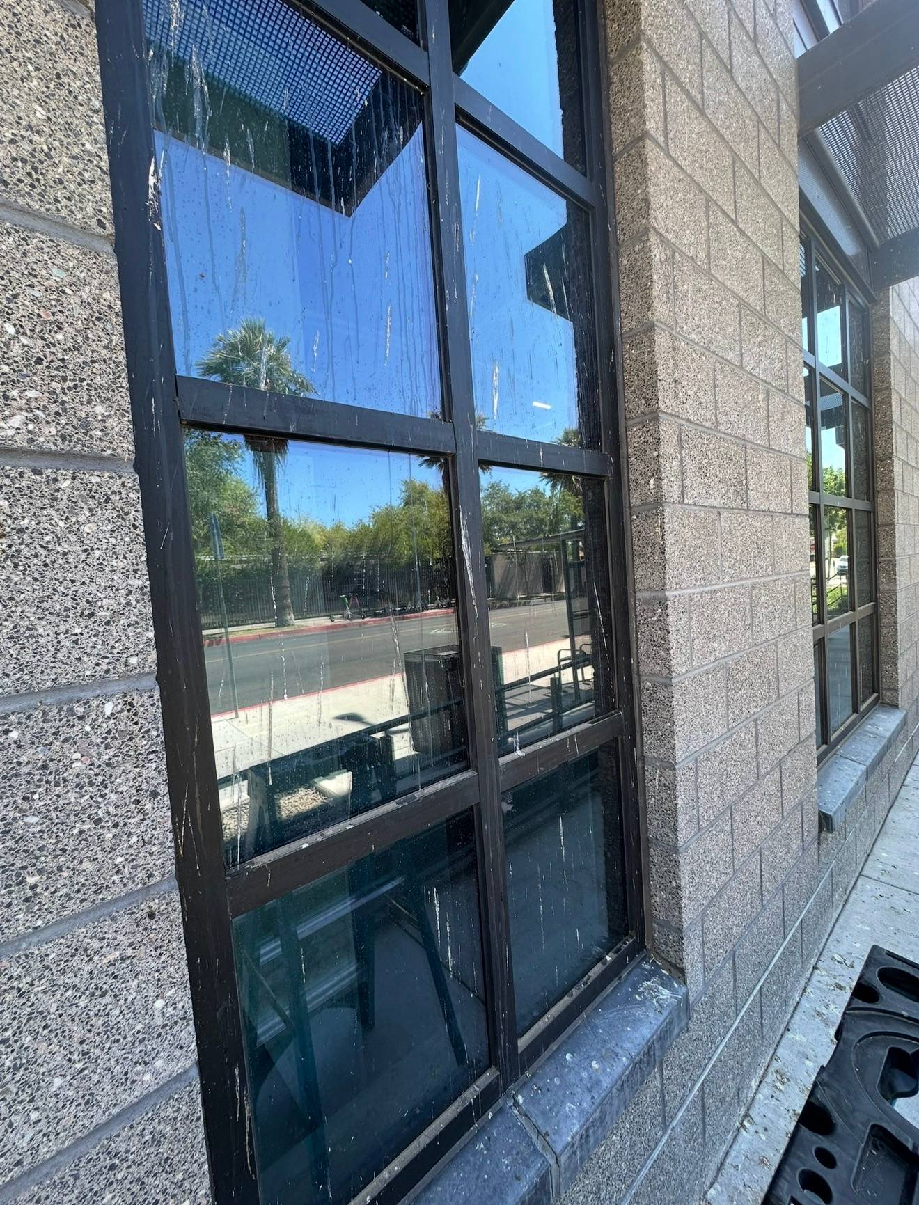 A commercial window before cleaning, streaked with dried run marks